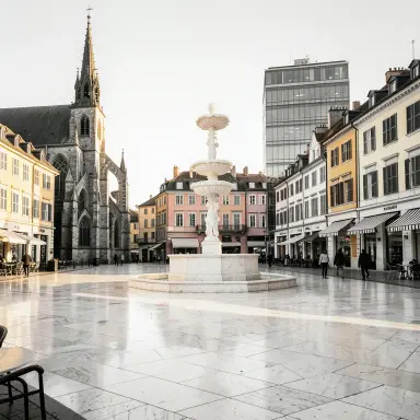a sunlit city square with a fountain and buildings of different eras, black and white photo style, FLUX.2